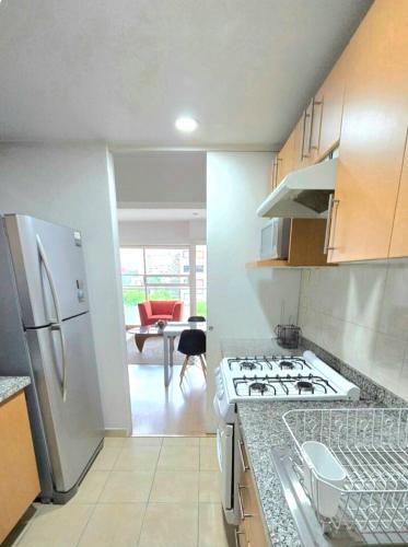 a kitchen with a stove and a white refrigerator at Residence Polanco, Security24h, Balcony, Pool, Gym, CarPark in Mexico City