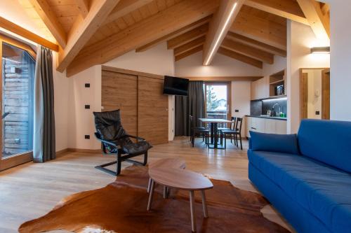 un soggiorno con un divano blu e un tavolo di Chalet Layla a Livigno