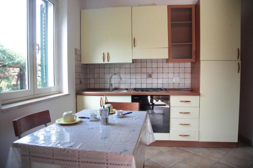 a kitchen with white cabinets and a marble counter top at Residenza La Vigna in Parghelia