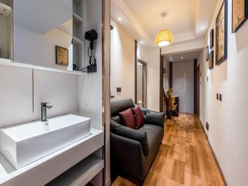 een woonkamer met een wastafel en een bank bij Annie Apartment 3206 in Kunming