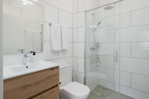 een badkamer met een douche, een toilet en een wastafel bij Residência Lord Freitas I by An Island Apart in Funchal