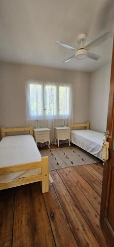 een slaapkamer met twee bedden en een plafondventilator bij casamila in San Javier