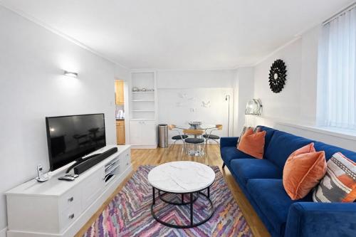 a living room with a blue couch and a tv at Camden Serviced Apartments by Globe Apartments in London