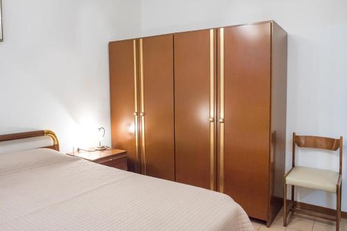 een slaapkamer met een grote houten kast naast een bed bij Numana, casa singola vista mare a 100mt dalla spiaggia in Numana