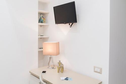 une table avec une lampe et une télévision murale dans l'établissement Il Vicoletto, à Amalfi