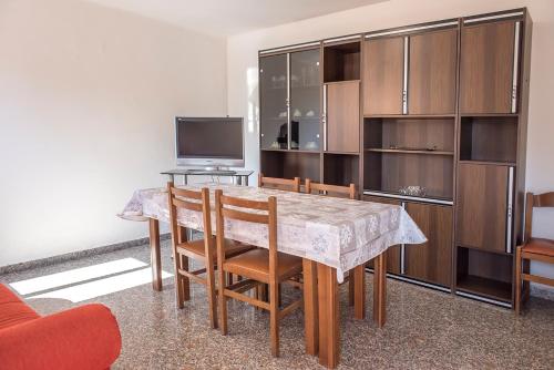 een eetkamer met een tafel, stoelen en een televisie bij Numana, casa singola vista mare a 100mt dalla spiaggia in Numana