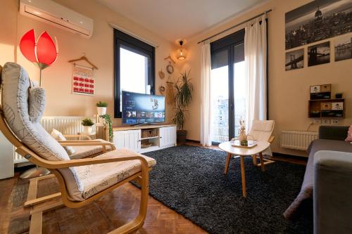 ein Wohnzimmer mit einem Stuhl und einem TV in der Unterkunft Urban Flat 2026 - At Central Square - Pet Friendly in Kavala