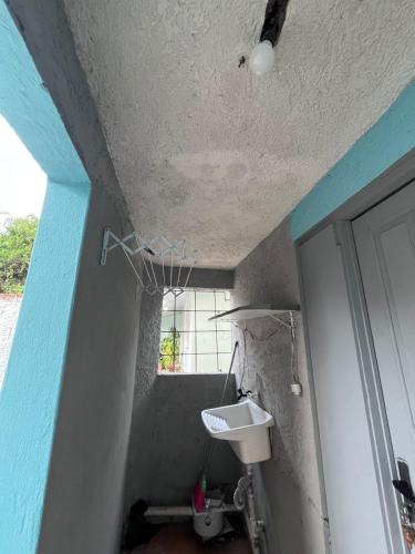 een badkamer met een witte wastafel en een blauw plafond bij Studio Apartamento in Capão da Canoa