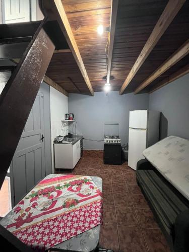 een kleine kamer met een bed en een koelkast bij Studio Apartamento in Capão da Canoa