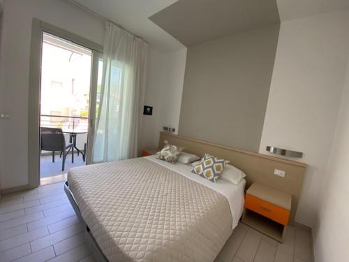 une chambre avec un lit et une grande fenêtre dans l'établissement Residenza Viel, à Bibione