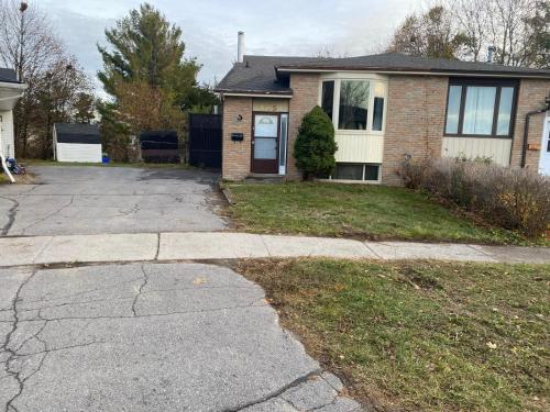 a house with a cracked sidewalk in front of it at Napaeno's Place - Home Away from Home in Kingston