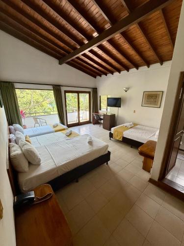 a bedroom with two beds and a living room at Hotel Balcones De Malibu in Medellín