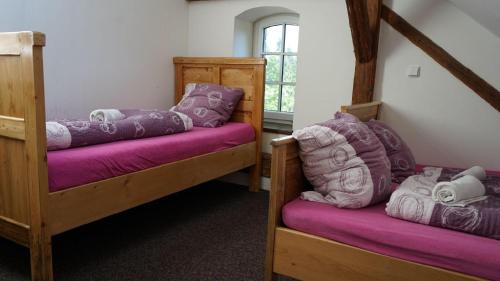 een kamer met twee stapelbedden met paarse kussens bij Penzion Stará škola Klíny in Klíny
