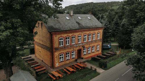 een bovenaanzicht van een groot bakstenen gebouw met banken bij Penzion Stará škola Klíny in Klíny