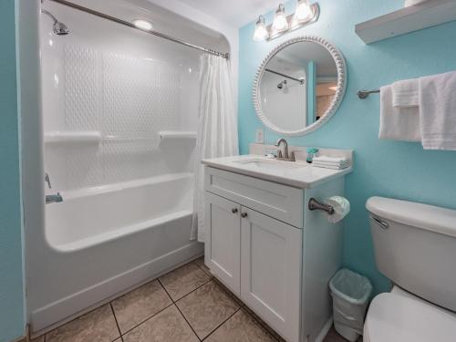Un baño con bañera, lavabo y espejo. en Beautifully Renovated Oceanfront 1BR! Roxanne Towers 303, en Myrtle Beach