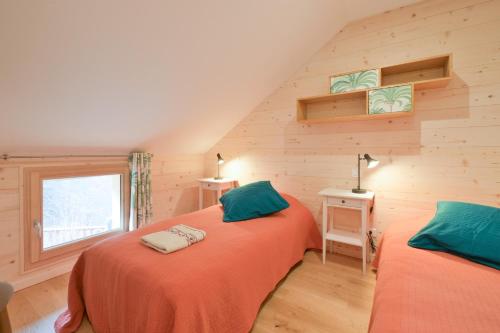 2 letti singoli in una camera con pareti in legno di Chalet La Hulotte a Brides-les-Bains