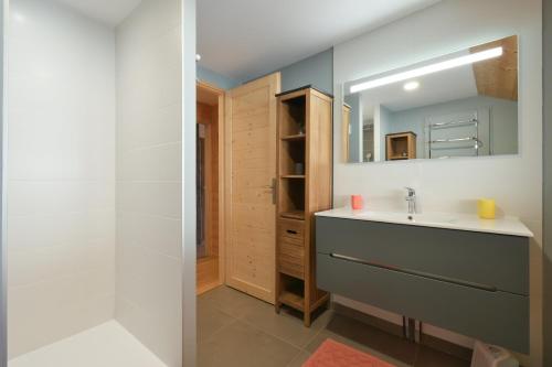 un bagno con lavandino e specchio di Chalet La Hulotte a Brides-les-Bains