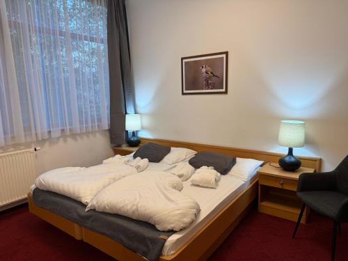 een groot bed in een kamer met een stoel bij Thermal Hotel Tengelic 