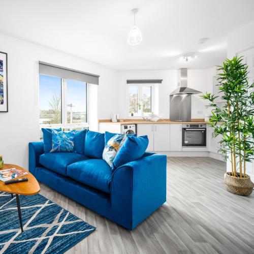 a blue couch in a living room with a kitchen at Modern Two Bed Apartment - Sleeps 3 - WiFi & Parking Included 57C in Sleightholme