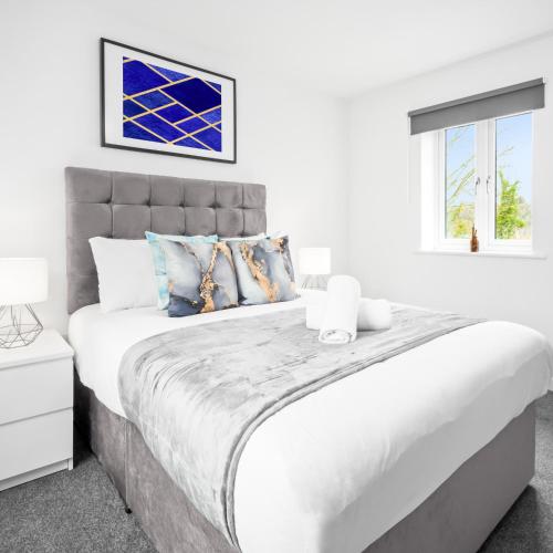 a white bedroom with a large bed and a window at Modern Two Bed Apartment - Sleeps 3 - WiFi & Parking Included 57C in Sleightholme