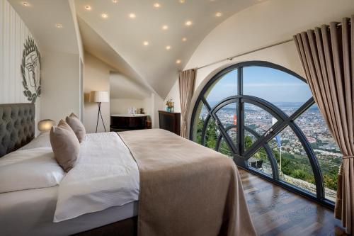 a bedroom with a large bed and a large window at UTO KULM - Top of Zurich in Zurich