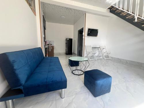 a living room with a blue couch and a table at Mia Homestay and Coffee in Bảo Lộc