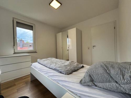 a bedroom with a bed and a window at HAVENU Ludwigsburg Mitte in Ludwigsburg