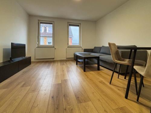 a living room with a couch and a tv at HAVENU Ludwigsburg Mitte in Ludwigsburg
