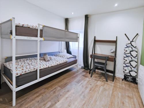 ein Schlafzimmer mit zwei Etagenbetten und einem Schreibtisch in der Unterkunft Vert Bocage Briard - Freedomus Marne-la-Vallée in Esbly