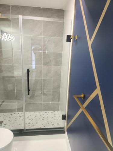 een douche met een glazen deur in een badkamer bij Modern Basement Suite • King Bed & 100” TV in Shrewsbury