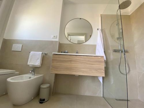 une salle de bain avec un lavabo, une douche et un miroir dans l'établissement Residenza Viel, à Bibione