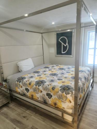 een bed met een bloemdekbed in een slaapkamer bij Modern Basement Suite • King Bed & 100” TV in Shrewsbury