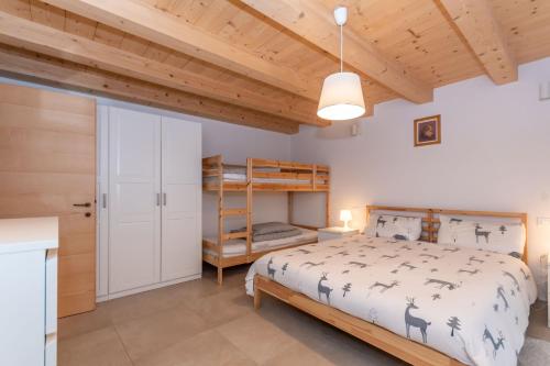 una camera da letto con un letto e un soffitto in legno di Ciasa al Caselo a Falcade