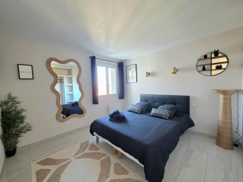 een slaapkamer met een blauw bed en een spiegel bij Appartement moderne, Centre Perpignan in Perpignan