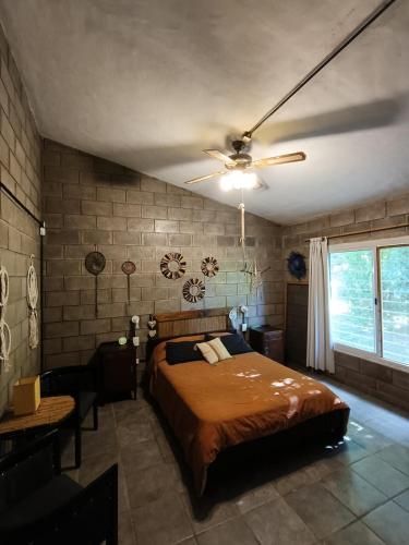ein Schlafzimmer mit Bett und Deckenventilator in der Unterkunft El Algarrobo Casa de campo en Cabalango in Cavalango