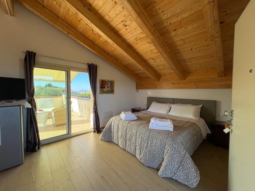 ein Schlafzimmer mit einem Bett und einer Glasschiebetür in der Unterkunft Villa Marianna in Alghero