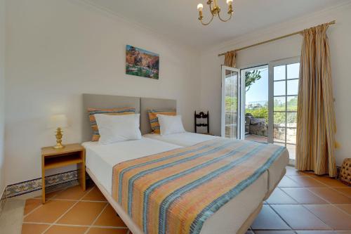 een slaapkamer met een groot bed en een raam bij Villa das Buganvilias by Delilah Collection in Albufeira