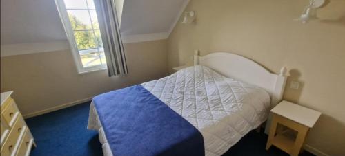 a small bedroom with a bed and a window at Maisonnette duplex 4 pers proche mer et golf in Talmont