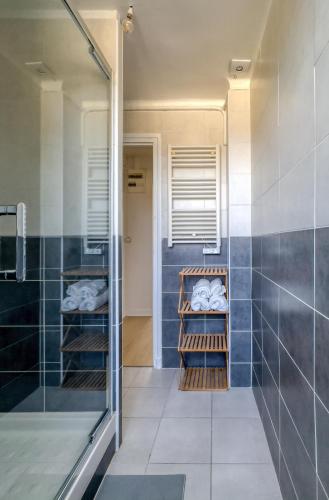 a bathroom with a shower with blue tiles at L'Oscar Imperial in Compiègne
