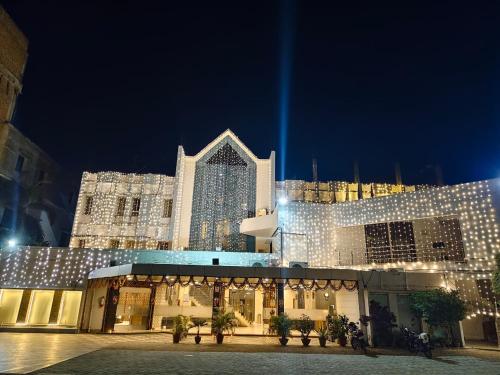 un grand bâtiment avec des lumières allumées la nuit dans l'établissement Hotel The Siwan International, à Siwān