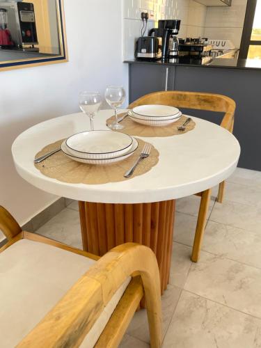 - une table blanche avec deux verres à vin dans l'établissement Coral Sands - BriSta Stays, à Mombasa