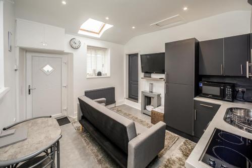 een woonkamer met een bank en een tafel bij Cottage hide-out in Kirkheaton