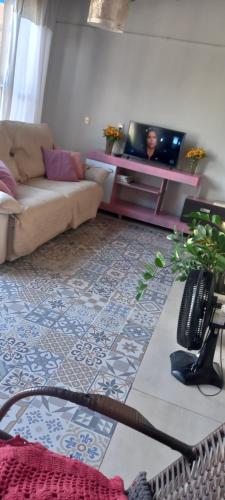 een woonkamer met een bank en een tv bij Casa in Bonito