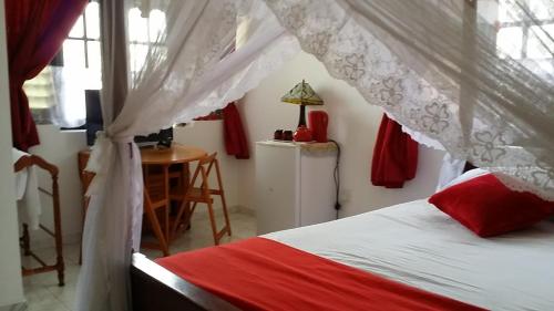 a bedroom with a bed with a red and white canopy at Sunset Beach Residence in Panadura