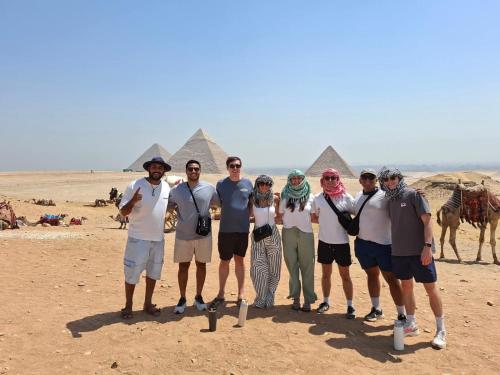 a group of people standing in front of the pyramids at Miami Hotel in Cairo