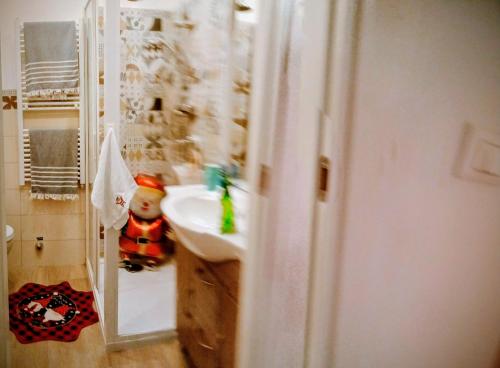 a bathroom with a elf doll standing in a sink at La perla di Maria in Grado