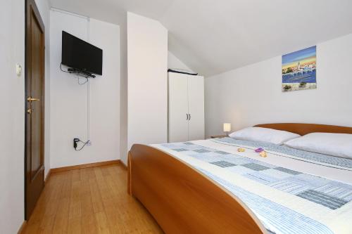 a bedroom with a bed with a television on the wall at Apartment Jasenka in Pakoštane