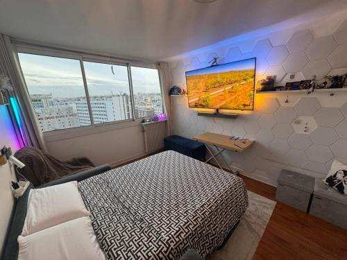 ein Schlafzimmer mit einem Bett und einem Fernseher an der Wand in der Unterkunft Guest room in a shared apartment - Metro 7 and Tramway T3a in Paris