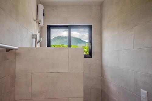 a bathroom with a shower with a window at Hotel Arenal by Regina in Fortuna