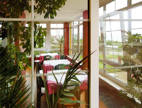 a room with tables and chairs and a window at Hotel Restaurante el Fornon in Novellana